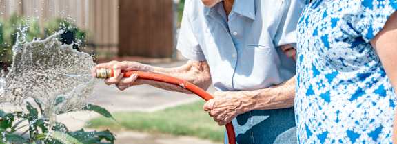 pouring water on plants at White Springs Senior Living, Warrenton, VA 20186