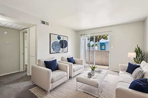 A living room with white furniture and a blue abstract painting on the wall.
