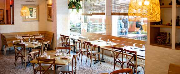 A restaurant with wooden chairs and tables.