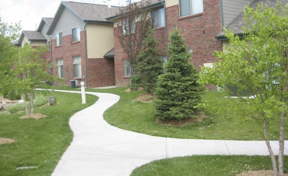 A sidewalk trail in front of a brick apartment building