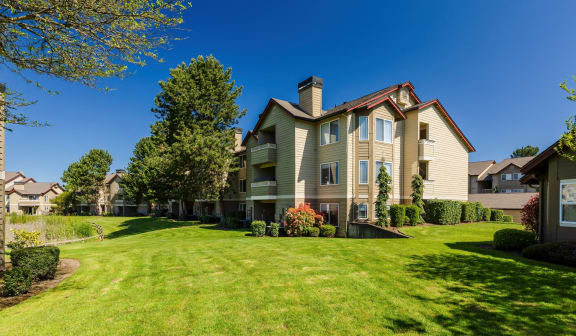 a large house with a green lawn and a blue sky