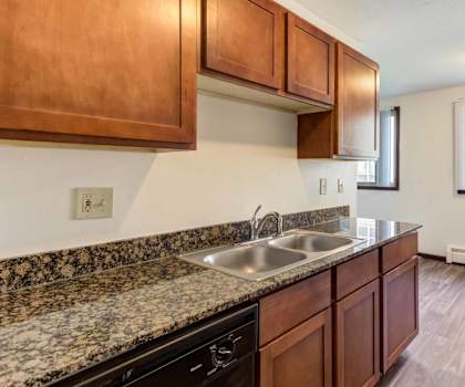 a kitchen with wood cabinets and granite countertops