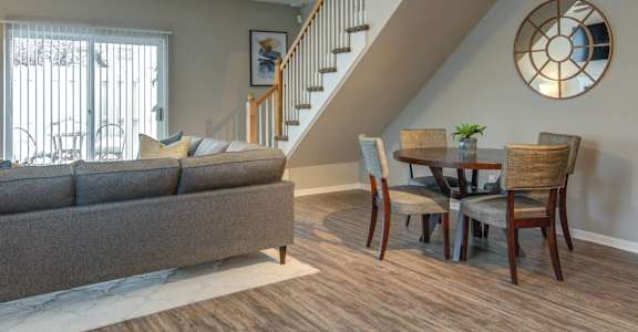 A living room with a grey couch and a wooden floor.