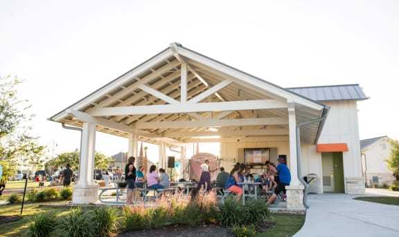 People Gathered Under Awning in Park