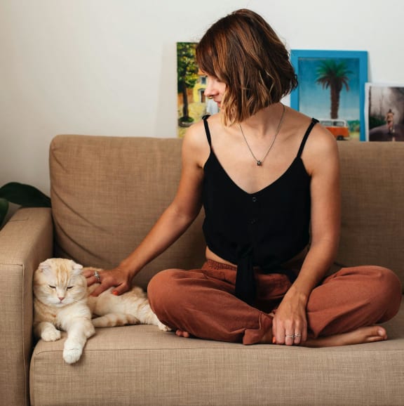 a woman laying on a bed with a cat on her face at Staples Mill Townhomes, Virginia