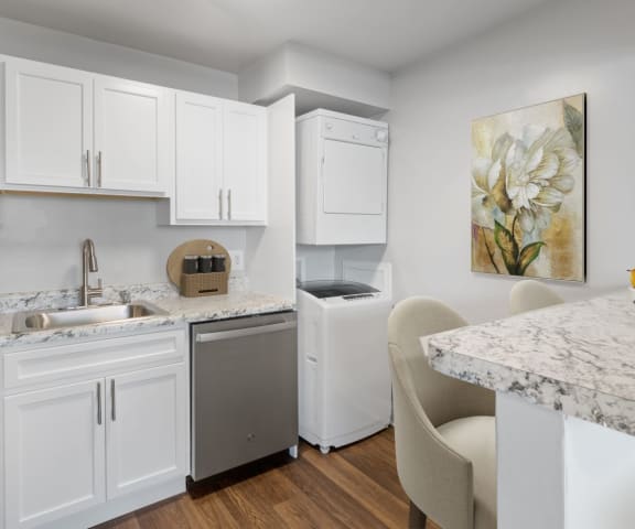 a kitchen with white cabinetry and a countertop with a bowl of fruit on it at Falls Village Apartments, Baltimore MD