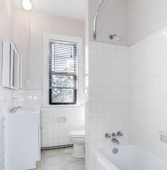 a white bathroom with a tub and a toilet and a sink