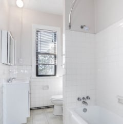 a white bathroom with a tub and a toilet and a sink