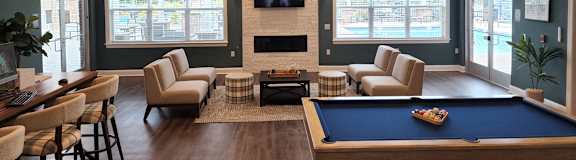 A room with a pool table and a fireplace.