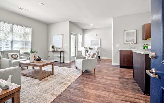 A modern living room with a grey sofa, a wooden coffee table, and a blue door.