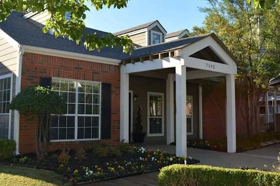A house with a red brick facade and white columns.