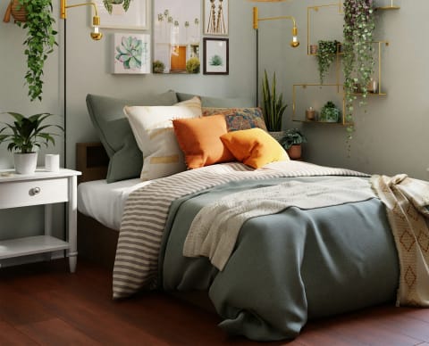 a bedroom with green walls and a bed with orange and white pillows
