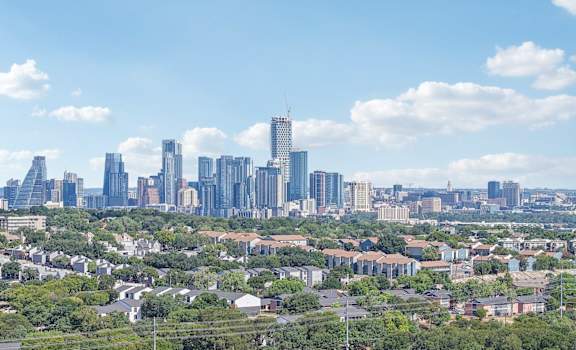 A cityscape with a mix of residential and commercial buildings under a clear sky.