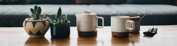a table with coffee cups and a couch in the background