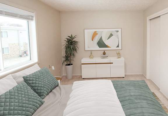a bedroom with a large bed next to a window