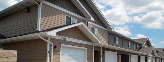 a row of garages in a row with a cloudy sky in the background