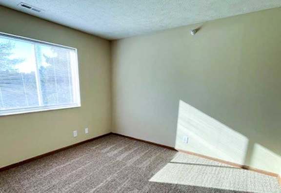 a bedroom with a carpeted floor and a window