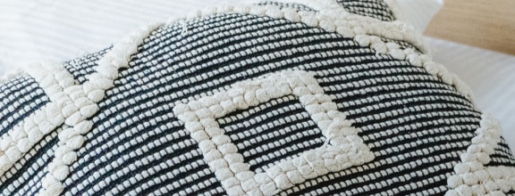 a pillow with a monogram on a bed