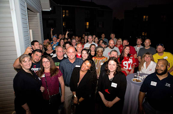 A group of people are gathered for a photo at night.