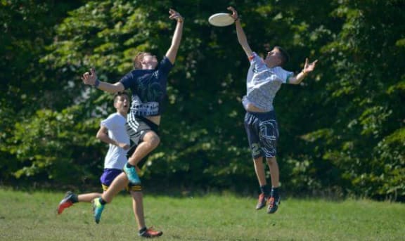 a group of young men playing a game of frisbee