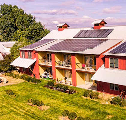 A red house with solar panels on the roof.