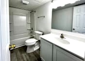 Thumbnail 10 of 15 - A white toilet is in a small bathroom with a white sink.