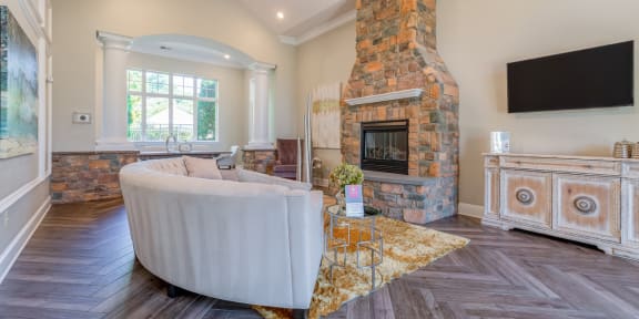 a living room with white couches and rattan chairs