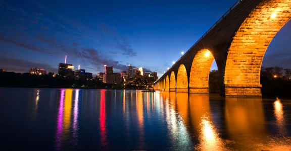 the bridge at night with the city in the background