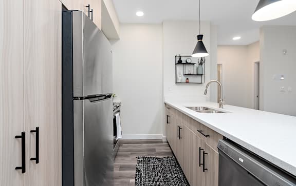 A modern kitchen with a stainless steel refrigerator and wooden cabinets.