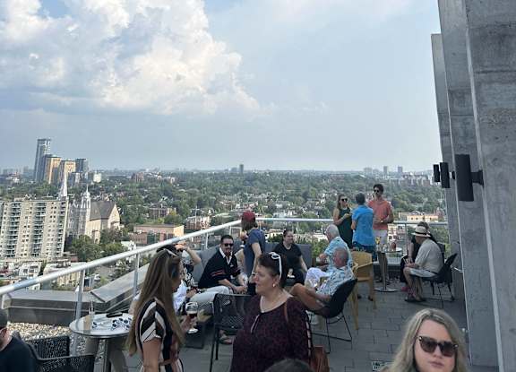 a view of the city from the top of a building with people sitting at tables