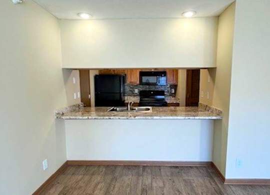 a kitchen with a windowed bar countertop facing the living room