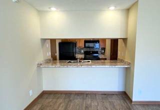 a kitchen with a windowed bar countertop facing the living room