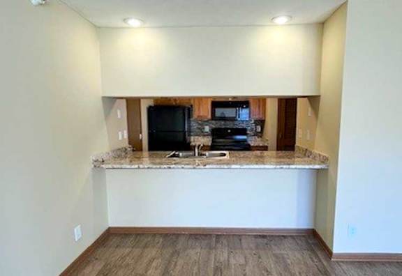 a kitchen with a windowed bar countertop facing the living room