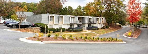 A row of houses with trees in front of them.