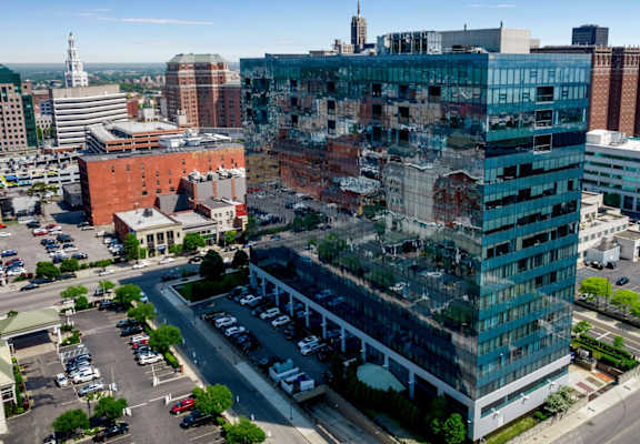 A large building with a lot of windows in the middle of a city.