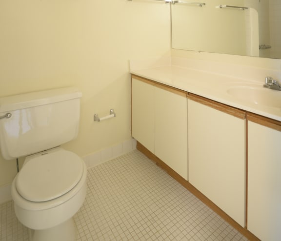 a bathroom with a toilet sink and mirror  at Charlesgate Apartments, Towson, Maryland