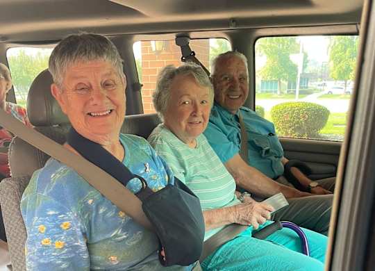 Elderly people are sitting in a car at River Commons Senior Living, Redding