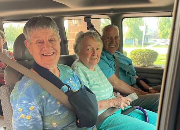 Elderly people are sitting in a car at River Commons Senior Living, Redding