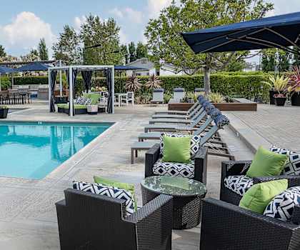 a swimming pool with lounge chairs and umbrellas at the resort at governors crossing at Harbor Pointe, California