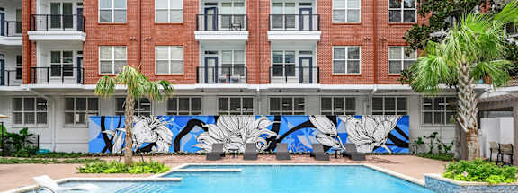 Swimming pool with and lounging chairs at The Grand at Upper Kirby apartments in Houston, TX