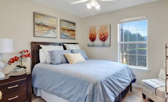 A bedroom with a large bed and a ceiling fan.