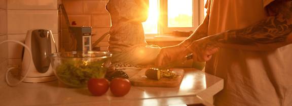 A man and a woman are preparing food in a kitchen.