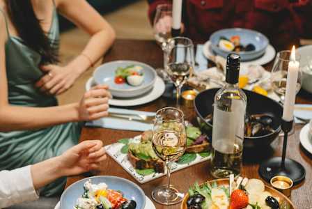 A group of people are sitting around a table enjoying a meal together.