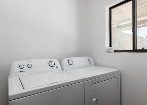 A white washing machine and dryer in a laundry room.