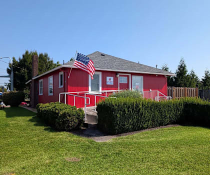A red house with an American flag on the roof.