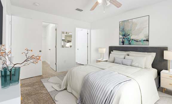 A bedroom with a large bed and a ceiling fan.