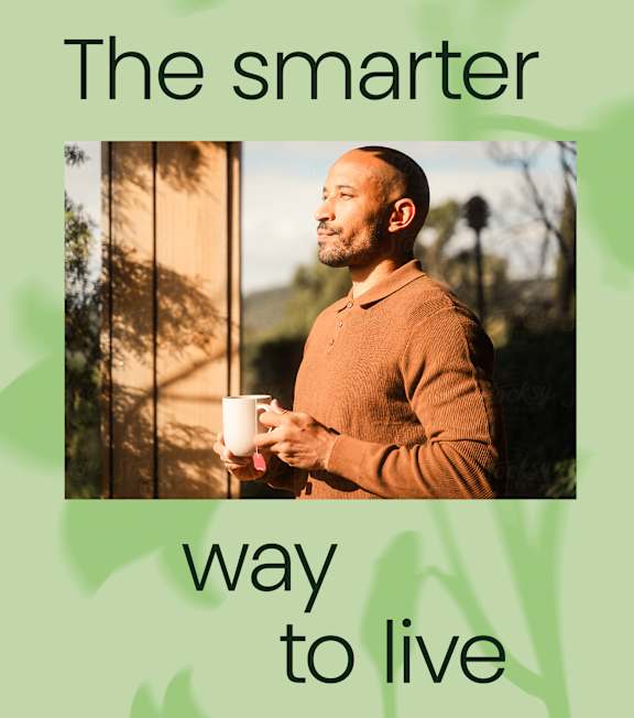 A man in a brown sweater holding a white mug with the text "The smarter way to live" above him.