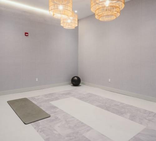an empty room with two chandeliers and a rug at Up House, Farmington, 06032