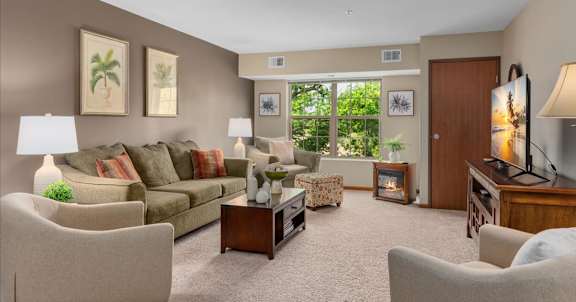 A living room with a couch, chairs, and a television.