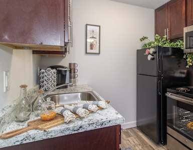 an apartment kitchen with black appliances and granite counter tops and a black stove and refrigerator at Weaver Farm, Florence, 41042